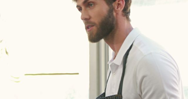 A young Caucasian man appears in a professional setting, a server or a bartender, with copy space. His attire suggests a service industry environment, adding a touch of sophistication to the scene.