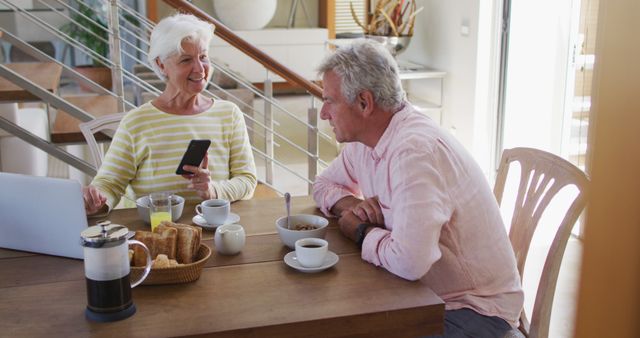 Senior couple enjoying breakfast while using technology - Download Free Stock Images Pikwizard.com