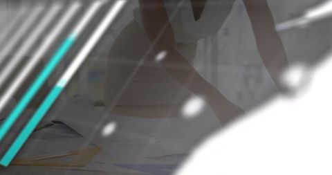 Architect leaning over drafting table arranging blueprints with teal accents