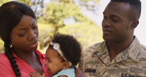 Military Father Comforting Crying Baby in Family Moment