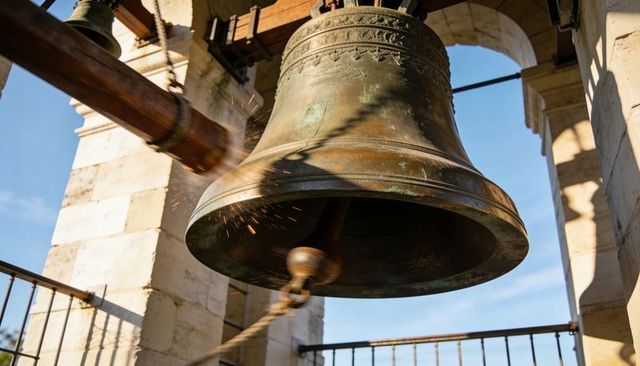 Swinging bronze bell emitting sparks in historic campanile