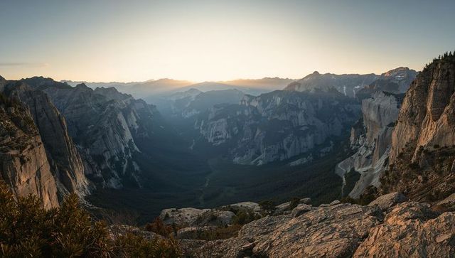 Sunrise over granite canyon panoramic mountain valley from rocky overlook dramatic cliffs