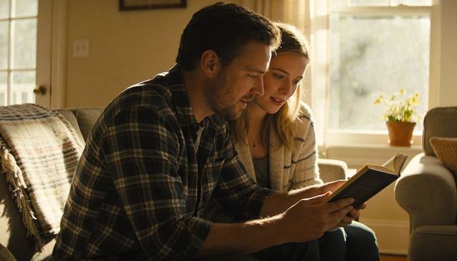 Couple reading together on sunlit sofa cozy domestic moment with paperback book