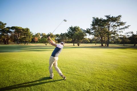 Senior Man Enjoying Golf Swing on Golf Course