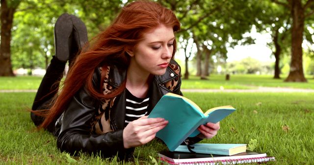 Young woman reading in park, relaxing on grass - Download Free Stock Images Pikwizard.com