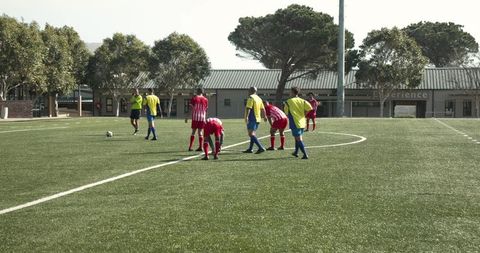Soccer Players in Red Uniforms Preparing for Match on Sunny Day