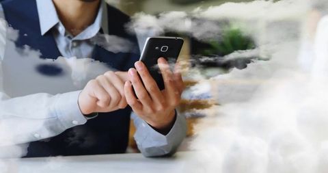 Business Professional Using Smartphone in Modern Office with Cloud Overlay
