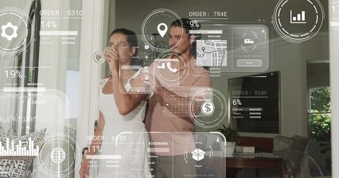 Couple exploring augmented reality home interface while sipping drinks by glass door