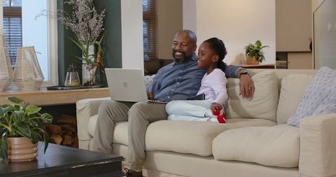 Father and Daughter Using Laptop in Cozy Living Room