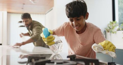 Father and son cleaning kitchen together for a sparkling home
