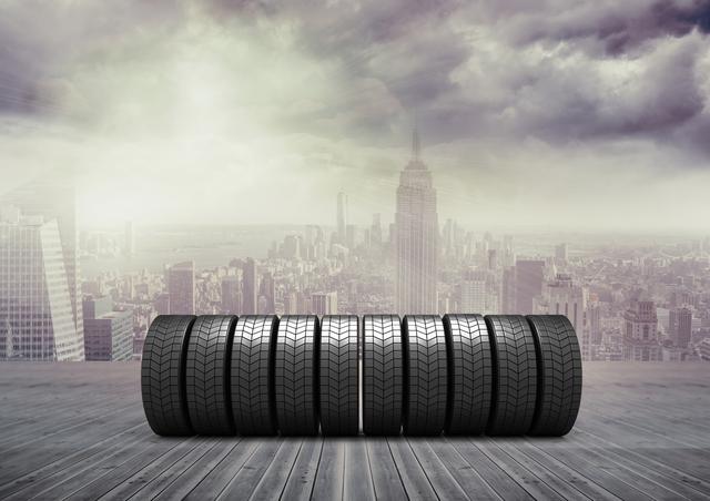 Digital composition of stack of tyres on wooden walkway against cityscape background
