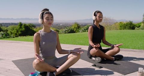 Women Meditating Outdoor with Headphones, Embracing Mindfulness