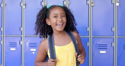 Joyful Student with Backpack Smiling in Front of School Lockers