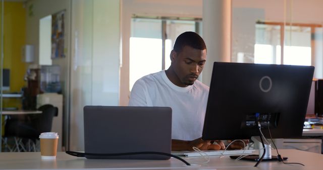 Young male executive working on computer at desk in modern office. Young male executive sitting on desk 4k