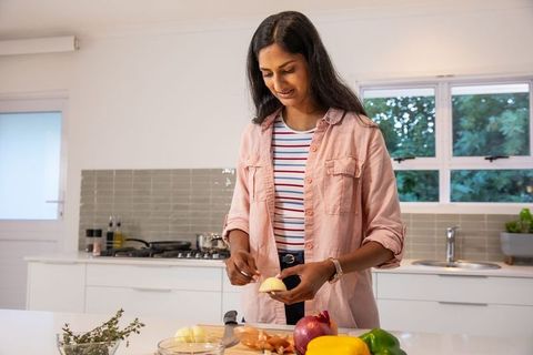 Woman preparing meal in modern kitchen with fresh vegetables