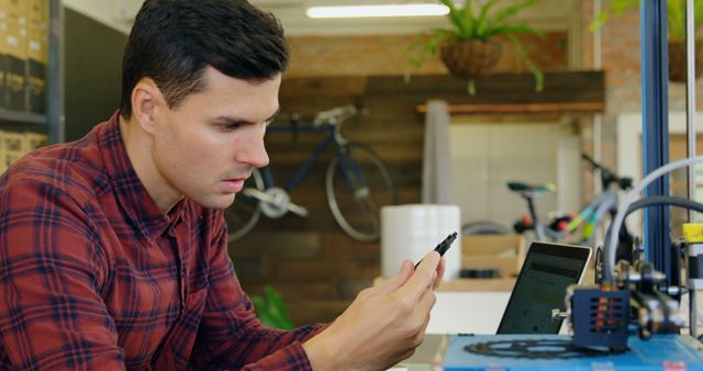 Man using smartphone at workplace with 3D printer - Download Free Stock Images Pikwizard.com