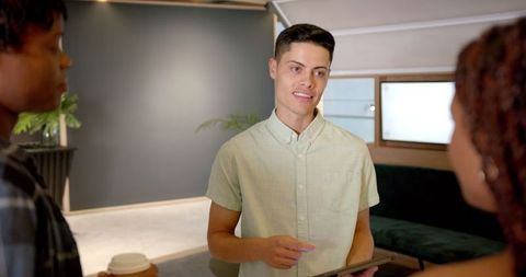 Businessman Discussing Project Details with Colleagues Using Digital Tablet