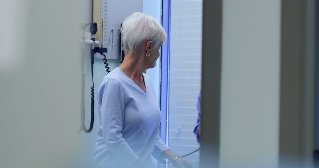 Senior woman waiting in medical clinic corridor - Download Free Stock Images Pikwizard.com