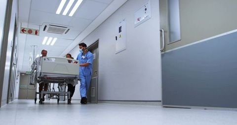 Medical team transporting patient on gurney through hospital corridor for urgent care