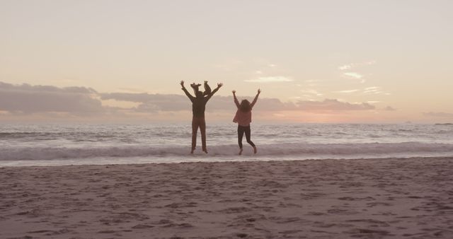 Couple Jumping on Beach at Sunset Celebrating Freedom - Download Free Stock Images Pikwizard.com