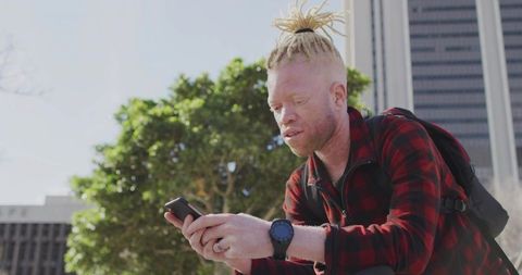 Man in Flannel with Smartphone in Urban Plaza in Spring