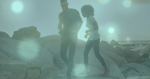 Friends hiking scenic rocky coastline during sunset