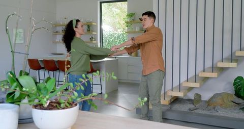 Couple Dancing Playfully in Modern Bright Kitchen