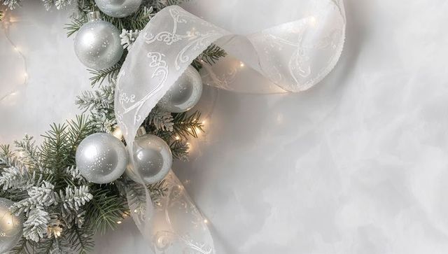 Silver holiday wreath with frosted pine sprigs, sheer ribbon and warm fairy lights