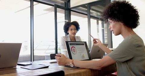 Professional Collaboration Reviewing Analysis on Laptop in Office