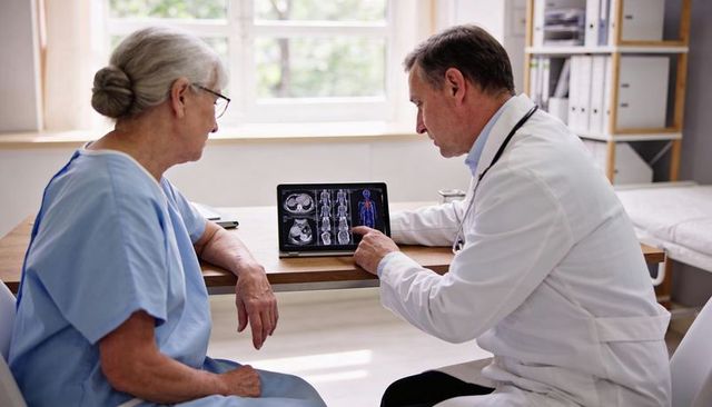 Doctor explaining ct scan results to senior patient using tablet in sunlit clinic