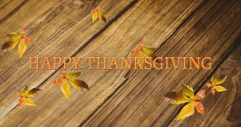 Thanksgiving Greeting with Autumn Leaves on Wooden Background