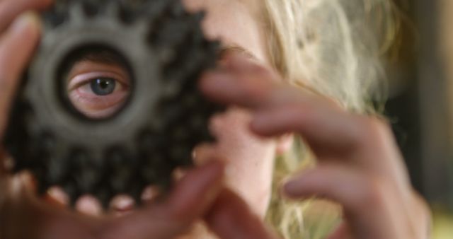 Creative Portrait of Young Woman Peering Through Gear at Home - Download Free Stock Images Pikwizard.com