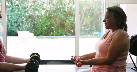 Senior couple engaging in fitness routine with weights at home