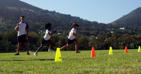 Children Running Through Cones with Coach on Sunny Day - Download Free Stock Images Pikwizard.com