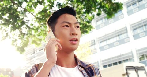 Young Asian Man Talking on Mobile Phone Outdoors