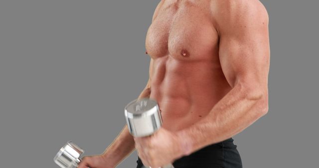 A muscular Caucasian man is lifting a dumbbell, focusing on his bicep workout, with copy space. His dedication to fitness and strength training is evident from his well-defined muscles.