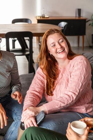 Friends Enjoying Relaxed Gathering on Cozy Couch at Home