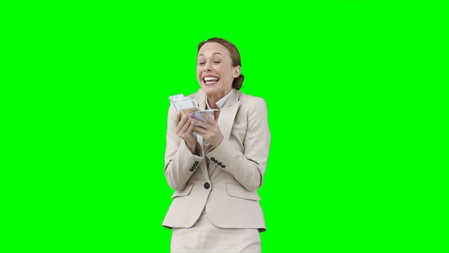 Businesswoman expressing excitement while counting money and shaking with joy against vibrant green background. Perfect for financial, banking, or economic themes; can be used in promotional materials, advertising, and presentations related to money, success, and prosperity.