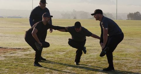 Team Performing Dawn Balance Drill on Dewy Field Wearing Caps and Athletic Training Gear