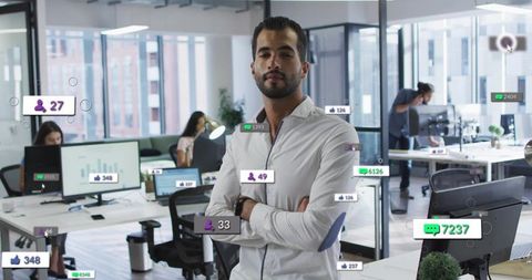 Confident man standing in modern open office with floating social media metrics