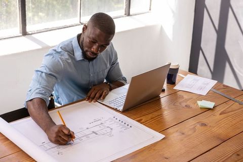 Architect Sketching Blueprints in Design Studio