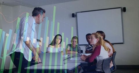 Teacher guiding teen learners in collaborative classroom with laptop and data overlay
