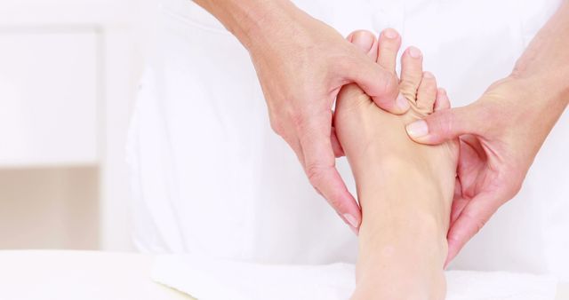 A person is receiving a foot massage from a therapist, with copy space. Foot massages can be a relaxing way to relieve stress and promote well-being.