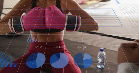 Female boxer sitting in corner holding pink gloves at chest with fitness analytics overlays