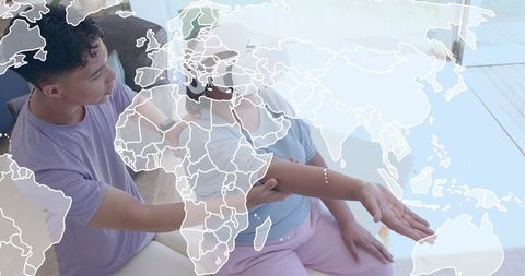 Caregiver supporting elderly woman on couch in bright room with translucent world map overlay