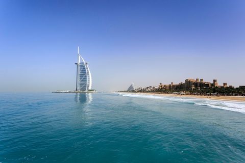 Iconic burj al arab against clear blue sky and ocean