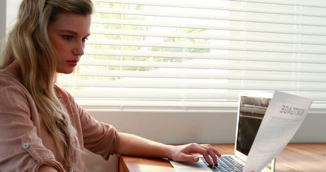 Focused Woman Reviewing Document at Home Office Desk - Download Free Stock Images Pikwizard.com