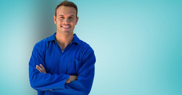 Serviceman standing with arms crossed against turquoise background