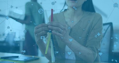 Asian Businesswoman Analyzing Data with Digital Network Icons in Office