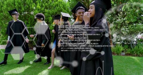 Diverse graduates walking across campus lawn wearing mortarboards with hexagon tech overlay